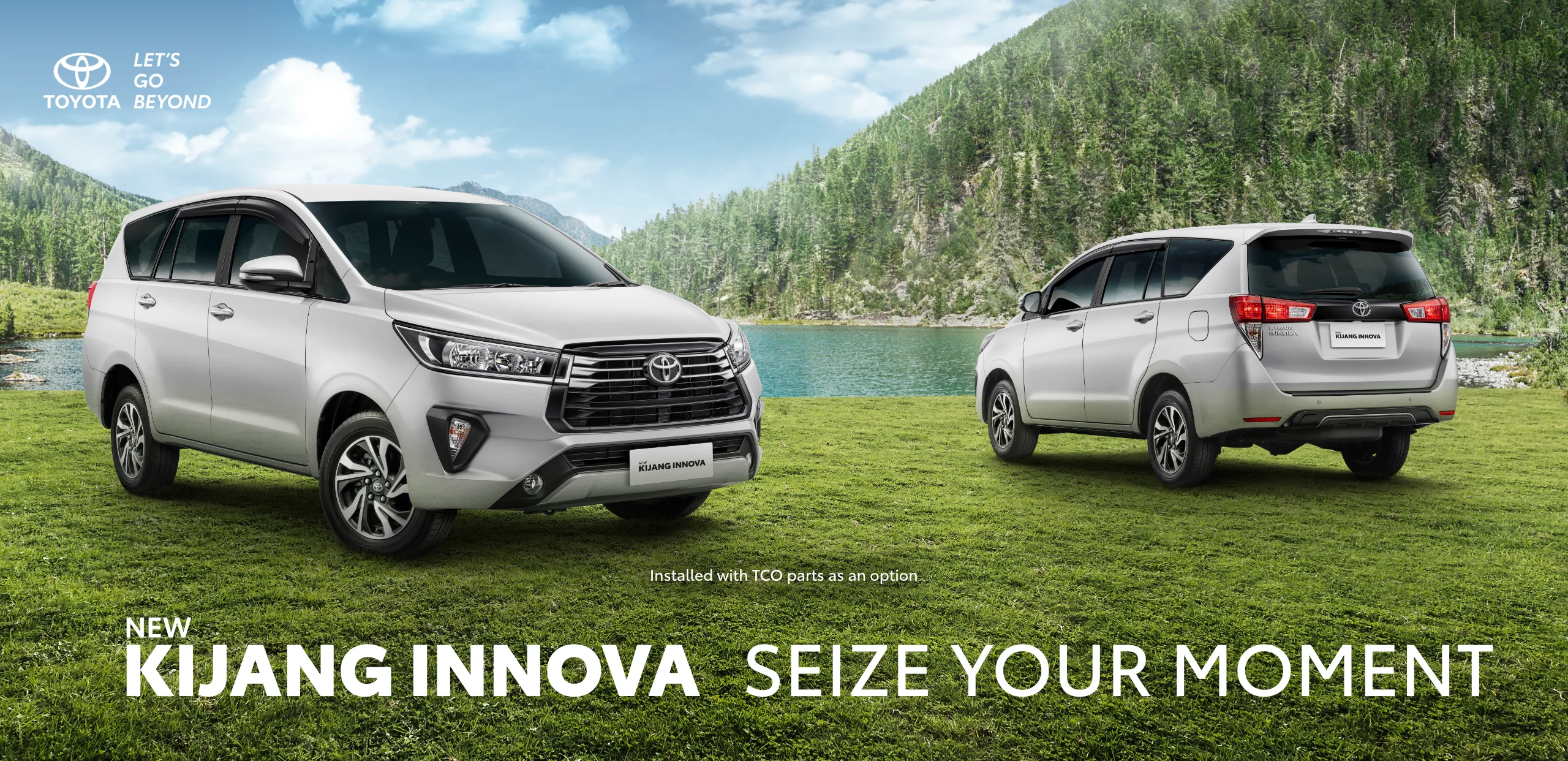 Banner promosi Toyota New Kijang Innova berwarna perak yang terparkir di padang rumput hijau dengan latar belakang danau dan pegunungan, menampilkan sisi depan dan belakang mobil beserta tagline Seize Your Moment.