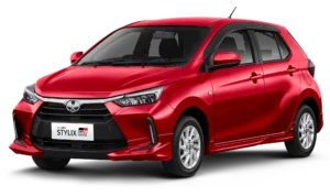 Mobil Toyota New Agya Stylix warna merah dengan tambahan aksesoris GR Parts, menampilkan desain hatchback yang sporty dan modern dari sudut depan samping.