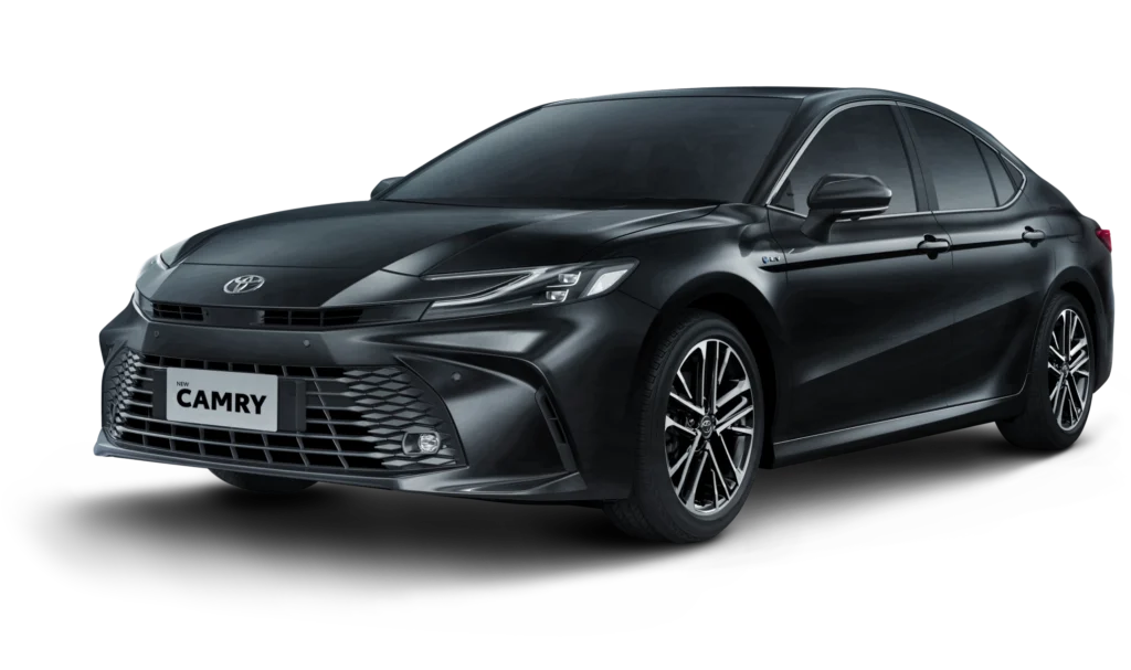 Mobil Toyota New Camry Tipe V varian mesin bensin (Gasoline) warna hitam, tampak serong depan menonjolkan desain sedan eksekutif yang aerodinamis, lampu LED tajam, dan grille elegan berlatar belakang hitam pekat.