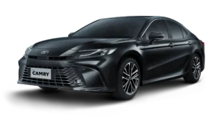 Mobil Toyota New Camry Tipe V varian mesin bensin (Gasoline) warna hitam, tampak serong depan menonjolkan desain sedan eksekutif yang aerodinamis, lampu LED tajam, dan grille elegan berlatar belakang hitam pekat.