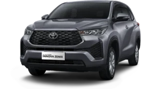Mobil Toyota All New Kijang Innova Zenix varian mesin bensin (gasoline) warna abu-abu, tampak serong depan menonjolkan grille heksagonal besar yang tangguh dan desain MPV crossover berlatar belakang hitam pekat.