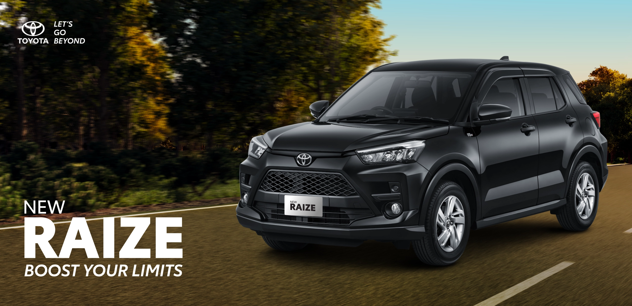 Mobil SUV kompak Toyota New Raize tipe G warna hitam melaju dinamis di jalanan beraspal dengan latar pemandangan pepohonan hijau. Banner promosi Tunas Toyota ini menampilkan tagline Boost Your Limits.
