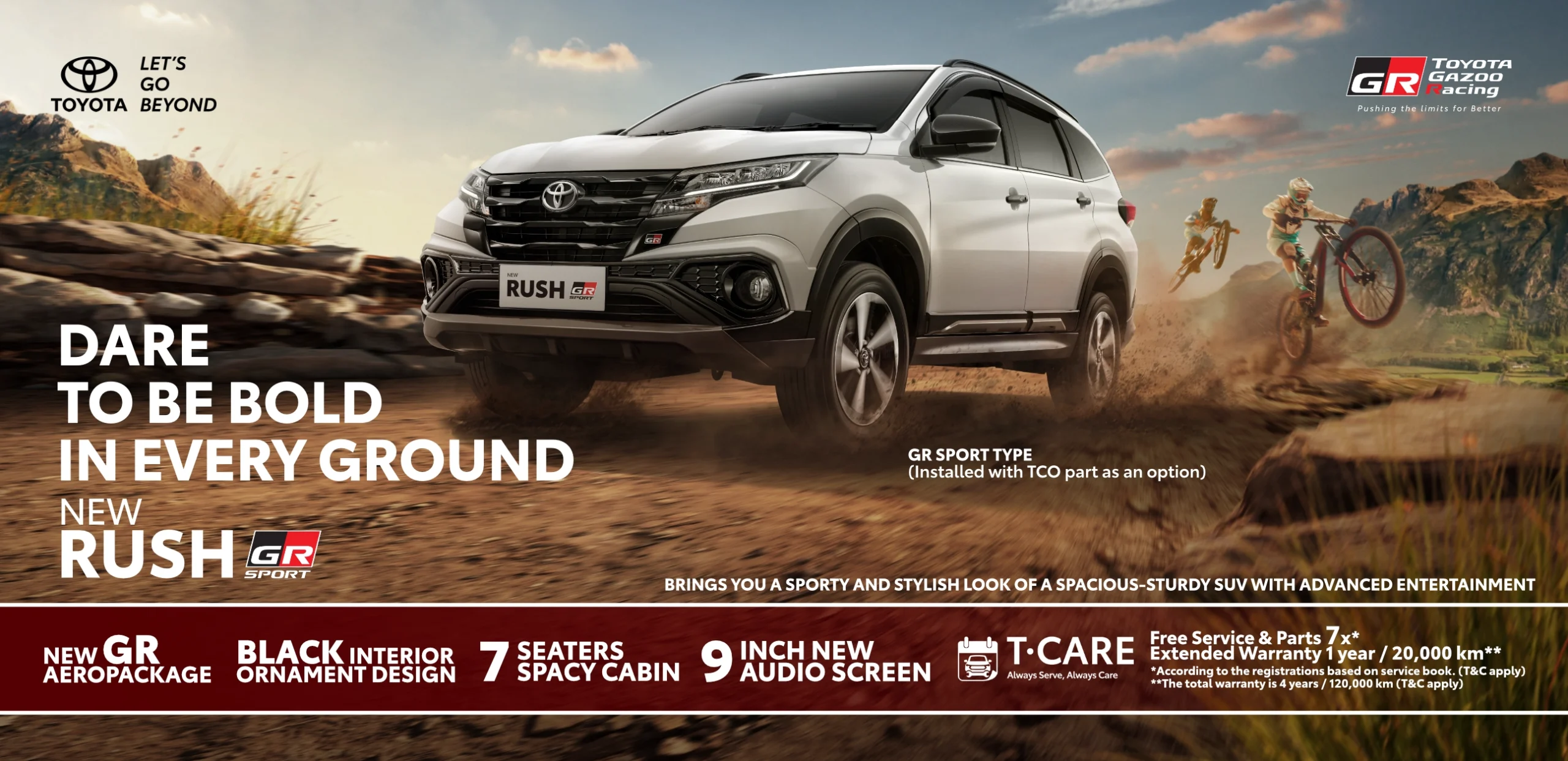 Banner promosi Toyota New Rush GR Sport warna putih melaju di jalur tanah berbatu dengan latar belakang pegunungan. Menampilkan tagline Dare To Be Bold In Every Ground, serta informasi fitur kabin 7 penumpang, GR Aeropackage, dan promo T-CARE.