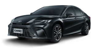 Mobil Toyota New Camry varian HEV (Hybrid Electric Vehicle) warna hitam, tampak serong depan menonjolkan desain sedan eksekutif yang aerodinamis, lampu LED tajam, dan grille elegan berlatar belakang hitam pekat.