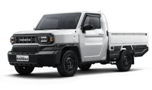 Mobil pikap komersial Toyota All New Hilux Rangga varian tertinggi (High) transmisi otomatis mesin diesel warna putih, tampak serong depan menonjolkan desain tangguh, bumper hitam kokoh, dan bak muatan berlatar belakang hitam pekat.