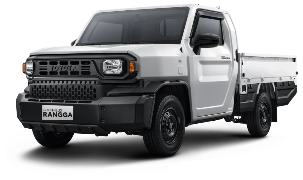 Mobil pikap komersial Toyota All New Hilux Rangga varian Standard transmisi manual (STD M/T) warna putih, tampak serong depan menonjolkan desain tangguh, bumper hitam kokoh, dan bak muatan berlatar belakang hitam pekat.