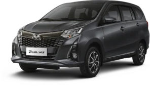 Mobil Toyota New Calya varian warna abu-abu gelap (Grey Metallic), tampak serong depan menonjolkan desain grille elegan bernuansa dark chrome dan headlamp modern berlatar belakang hitam pekat.