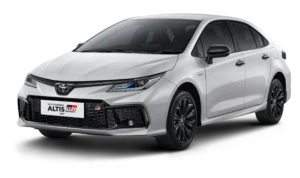 Tampilan studio tampak depan samping (3/4) mobil sedan Toyota New Corolla Altis HEV GR Sport warna putih dengan latar belakang hitam pekat. Terdapat sentuhan aksen hitam pada gril depan, spion, dan velg alloy, serta emblem GR pada bagian depan. Gambar produk utama resmi dari Tunas Toyota