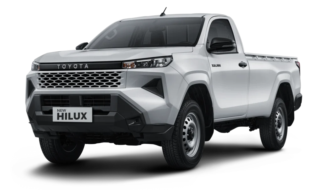 Mobil pikap komersial Toyota New Hilux Single Cabin varian warna putih, tampak serong depan menonjolkan desain tangguh, bumper depan kokoh, dan bak muatan luas berlatar belakang hitam pekat.