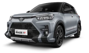 Tampilan studio tampak depan samping (3/4) mobil SUV kompak Toyota New Raize GR Sport warna silver dengan atap dan spion berwarna hitam (two-tone). Mobil ini berlatar belakang hitam pekat yang menonjolkan desain gril depan agresif, body kit aerodinamis GR Sport, lampu depan LED, serta velg alloy berwarna hitam. Gambar produk utama resmi dari Tunas Toyota.