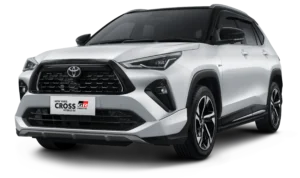Mobil compact SUV Toyota New Yaris Cross varian tertinggi S Hybrid EV dengan aksesoris GR Parts warna putih two-tone (atap hitam), tampak serong depan menonjolkan desain fascia sporty agresif berlatar belakang hitam pekat.