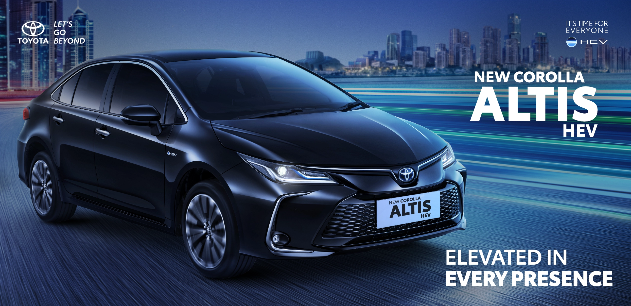 Mobil sedan hitam New Corolla Altis HEV melaju di jalan perkotaan dengan latar siluet gedung pencakar langit. Banner promosi dari Tunas Toyota ini dilengkapi tagline Elevated in Every Presence dan logo It's Time For Everyone HEV